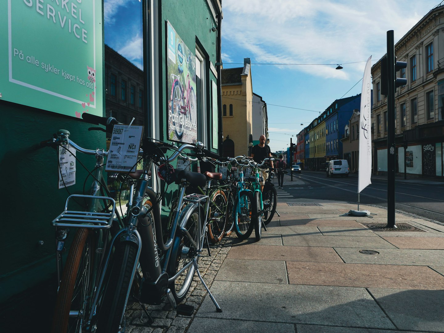 Cyklar parkerade utanför en cykelbutik på en stadsgata.